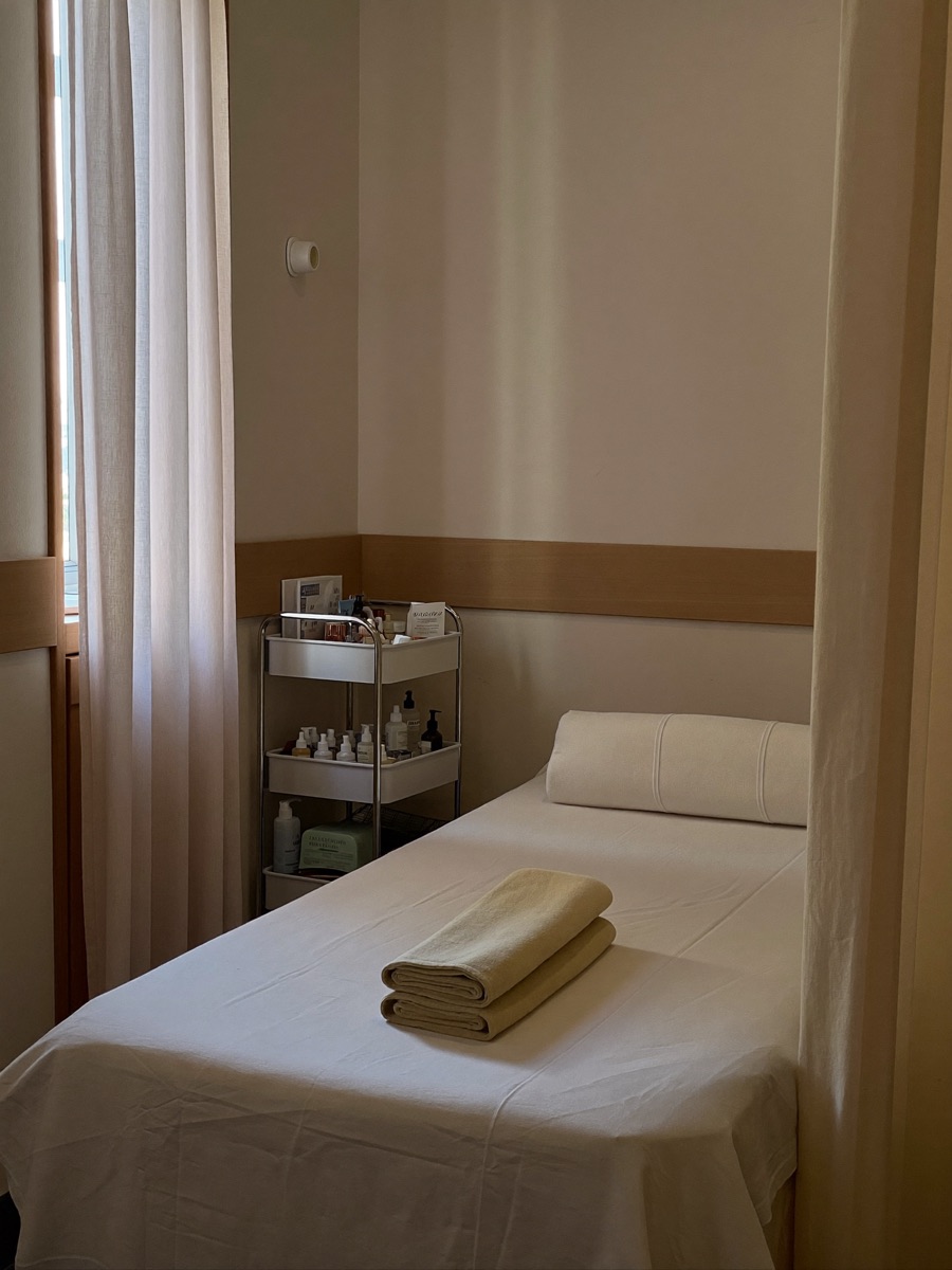 Cabina de tratamiento de un centro de estética con camilla y toallas