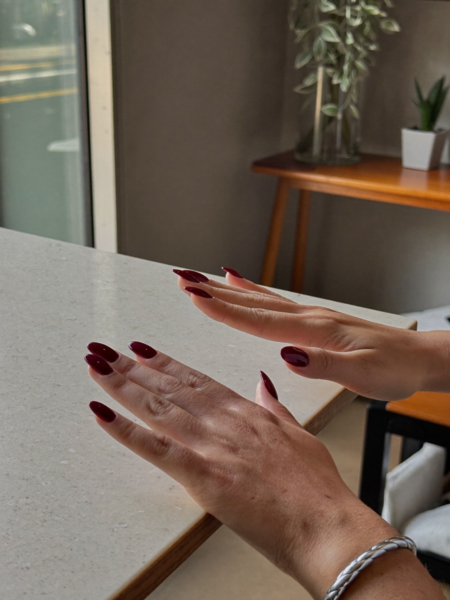Foto sin editar de unas manos con la manicura recién hecha, tomada con el móvil en el salón